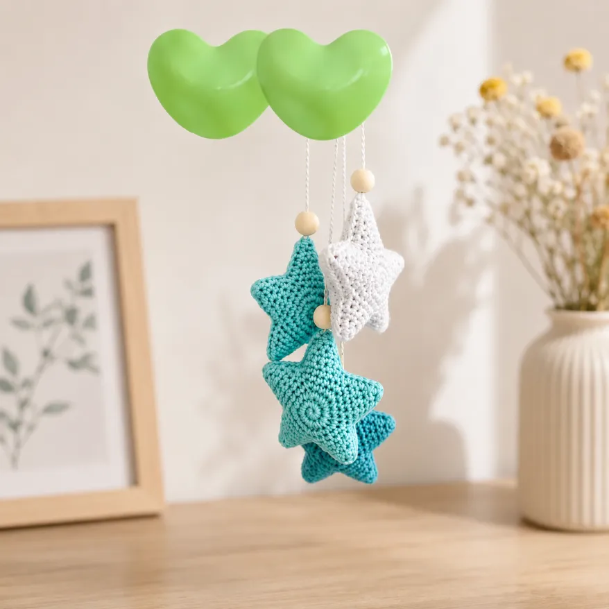 Beginner Small Crochet Star Pattern 2 Handmade Crochet Star Pattern hanging decoration with turquoise and white stuffed stars suspended from green heart-shaped balloons in a soft neutral home decor setting.