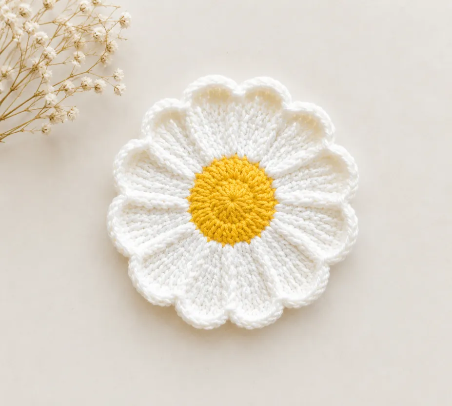Easy Crochet daisy Coaster Pattern (Beginner-Friendly) 1 White and yellow Crochet daisy Coaster Pattern on a soft beige background with minimal dried flowers, styled in a clean handmade aesthetic with natural lighting.
